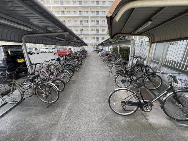 敷地内には多数の自転車を収容できる屋根付き駐輪スペースが設けられています。雨の日でもサドルや荷物が濡れにくく、自転車を日常的に利用するご家庭に便利な設備です。共用部分は平坦で移動しやすい。