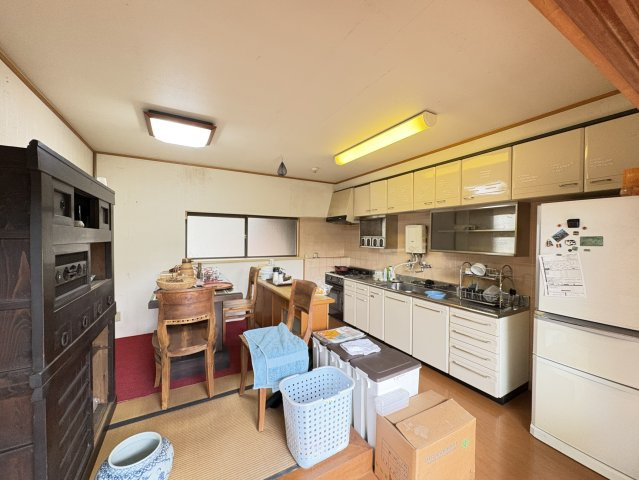 広々としたダイニングキッチンは、調理スペースと食事スペースをしっかり分けて使える実用的な間取りです。収納も豊富で、調理器具や食器類を整理しやすい設計です。窓からの採光もあり、明るい環境です。
