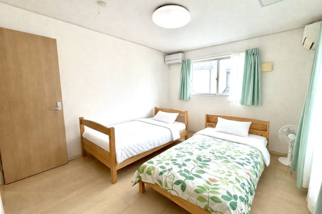 大きな窓とベランダへ出られるドアを備えた、開放感あふれる寝室。朝の光や風を感じながら一日を気持ちよくスタートできます。ベッドを2台置いても余裕のある広さで、ご夫婦の寝室や家族の主寝室に最適です。