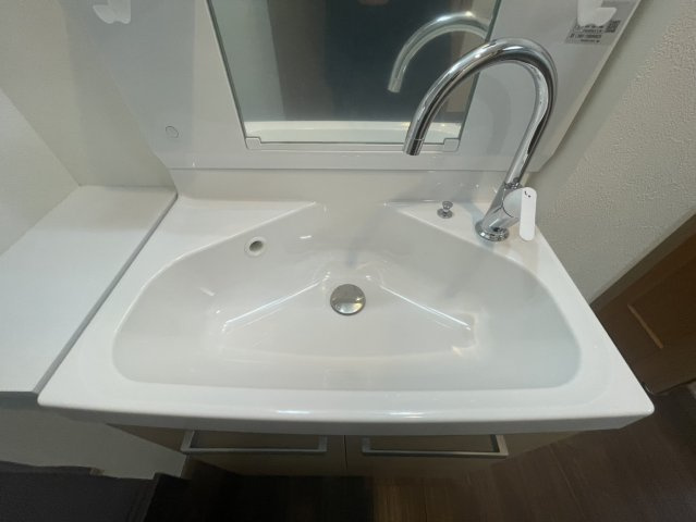 広さのある洗面ボウルを採用しており、水はねしにくく使い勝手の良い仕様です。シャワー水栓付きで洗髪やお掃除にも便利。ゆとりあるスペースが確保されているため、朝の忙しい時間帯も快適にご利用いただけます。