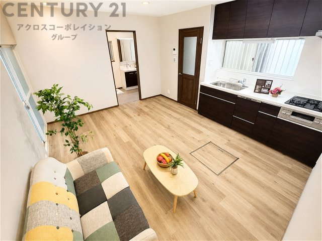 木目調のフローリングが温もりを感じさせる明るいLDK。壁付けキッチンで空間を広々と使え、家族団らんの時間もゆったり。窓から光が差し込む、心地よく開放感のある住空間です。