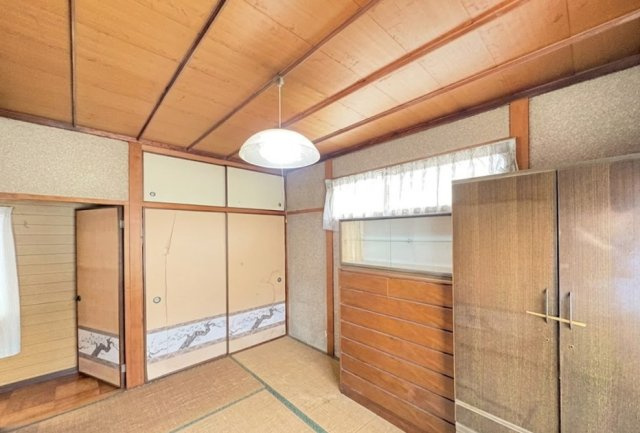 木目天井や和柄の襖が印象的な和室で、昔ながらの落ち着いた雰囲気を感じられる空間です。押入れ収納も備わっており、寝具や季節物などをすっきり整理可能です。窓から自然光が入り、明るさも確保されています。