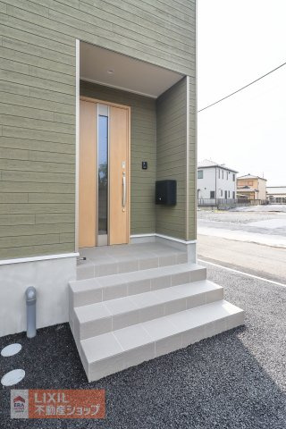 【エントランス／現地完成写真】屋根付きのポーチを採用して、雨の日に配慮。宅配ボックス設置をおススメ。