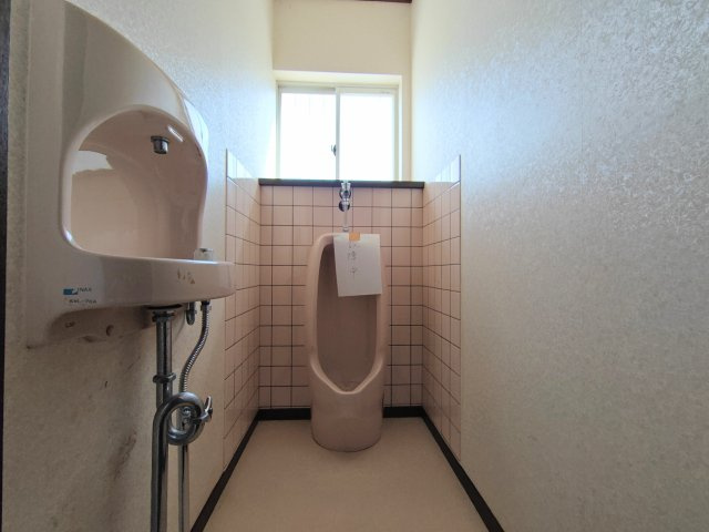 1階：小便器と手洗い器を備えたゆとりあるトイレ。窓付きで明るく、使い勝手にも配慮された空間です。