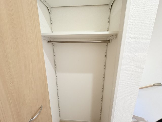 階段を上がった先には収納スペースを確保。棚やハンガーパイプが備えられており衣類や季節用品などを整理して収納可能。室内をすっきりと保ちやすく、暮らしやすさを高める便利なスペースです。