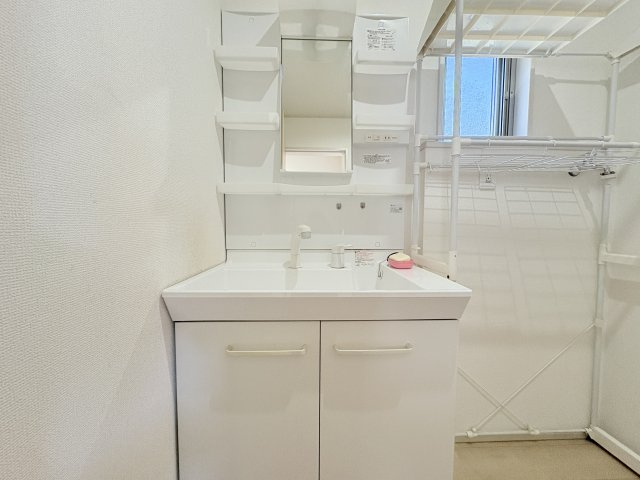 収納付きの洗面化粧台を備えており、洗面用品や日用品を整理しやすい仕様です。窓があるため換気もしやすく、明るさを取り込めるのもポイント。洗濯機置場も確保され、家事をまとめて行いやすい空間です。