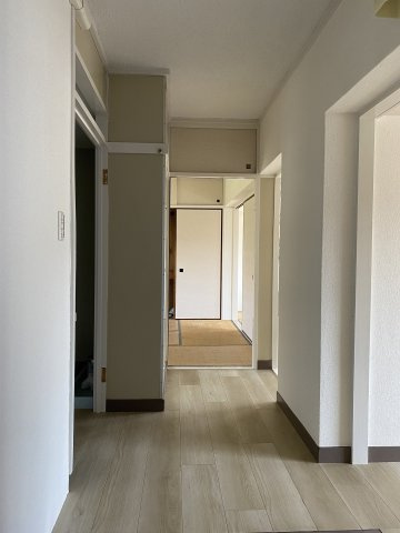 フローリングの重ね貼りとクロス貼替を行った明るい玄関です