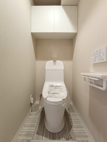 【トイレ】　スッキリとしたデザインの温水洗浄便座付きトイレ。小物やトイレットペーパーなどが目につかない状態で収納できます。