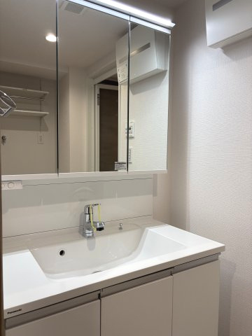 手元まで明るく照らすLED照明付きの洗面化粧台。スクエア型の広い洗面ボウルは、日々のお手入れやお洗濯の下洗いにも便利です。鏡の裏はすべて収納スペースになっており、細かなアメニティも綺麗に整頓できます。