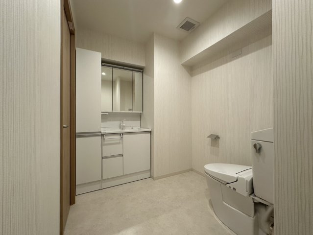 約11帖の洋室からつながる化粧室。脱衣室にあるものと同じ独立洗面台とトイレがあります。