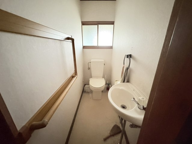 手すり付きで安心して利用できるトイレ空間。独立した手洗い器もあり、衛生面に配慮された設計です。窓付きのため換気もしやすく、明るく清潔感のある印象。将来を見据えた住まいとしても安心感のある設備です。