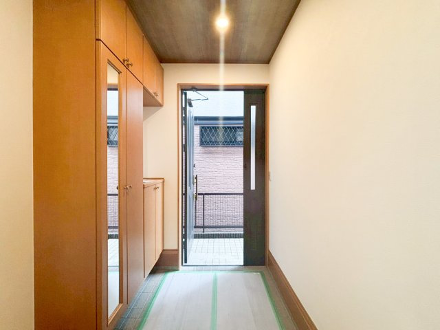 木の温もりを感じる清潔感のある玄関。天井までの大型シューズボックスと、姿見付きのトール収納で、家族全員の靴や外出グッズをすっきり収納できます。
