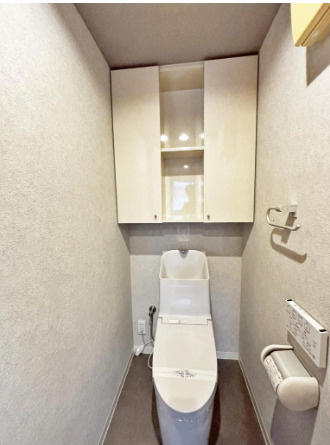明るく清潔感溢れるトイレです。温水洗浄便座付きで季節を問わずいつでも温かい便座をお使いいただけます。トイレットペーパーのストックや消耗品置き場、小物置きなどとしてもお使いいただける吊戸棚がございます。