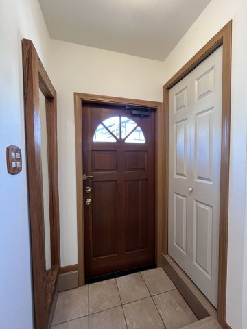 木目調で、上部に半円形のガラス窓付の玄関