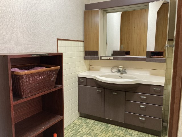 レトロなタイルと木目の収納が調和した古民家風の洗面スペース。広々とした洗面台は使い勝手が良く、朝の身支度も快適に行えます。収納棚も備わっており、タオルや日用品の整理もスムーズ。