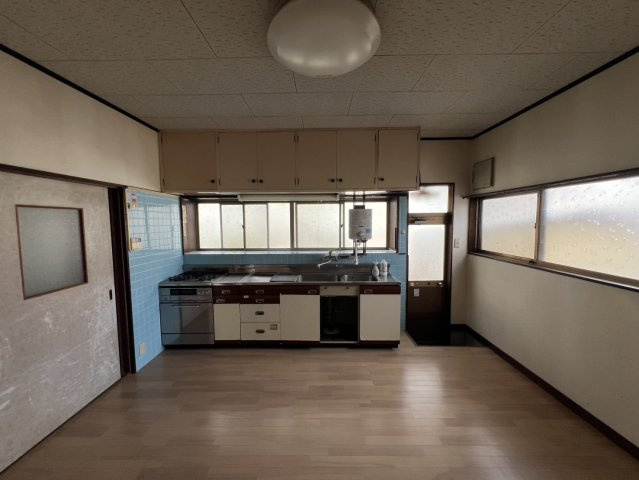 窓に面して設けられたキッチンは自然光を取り込みやすく、調理中の換気もしやすい配置です。シンクやコンロ、調理スペースを備え上部には吊戸棚を設置。食器や調理器具などを収納でき整理しやすいのもポイントです。
