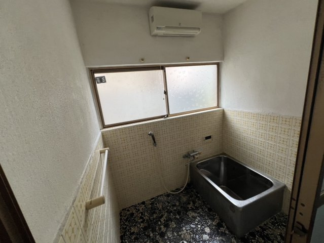 窓を備えた浴室で自然光を取り込みながら換気もしやすい造りです。ステンレス製の浴槽で壁面にはレトロな雰囲気を感じさせるタイルが施されています。既存設備を活かしたリフォームもご検討いただけます。