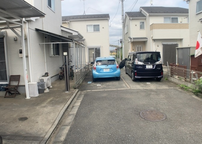 南接道の前面道路を含む現地外観写真です。南向きの土地であるため日当たりが非常に優れており、陽光が建物全体へ届きます。第一種低層住居専用地域に指定された静かな住環境で快適に生活を始めることができます。