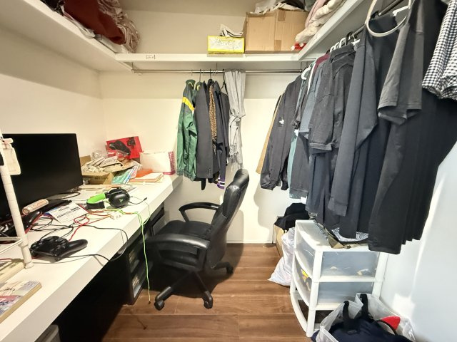 3.8帖のウォークインクローゼットは、衣類をたっぷり収納できるハンガーパイプと棚を備え、整理整頓がしやすい空間です。広さにゆとりがあり、デスクを設置してワークスペースとしても活用可能。