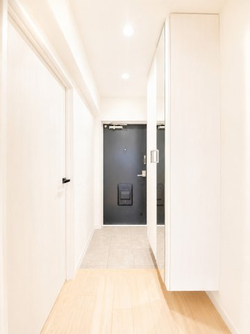 白基調の清潔感のある玄関。姿見付きの下駄箱があるため空間も広く感じるのが◎