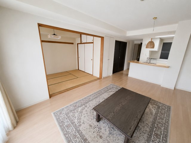 隣接する和室と一体利用で開放感あふれるLDK。対面キッチンを備え、ご家族との時間を快適に楽しめる空間