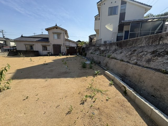 敷地を別角度から撮影した写真です。広々とした土地の奥行きや周辺環境を確認できます。敷地内には十分なスペースがあり、平屋住宅や二世帯住宅など幅広い建築計画にも対応しやすい土地となっています。