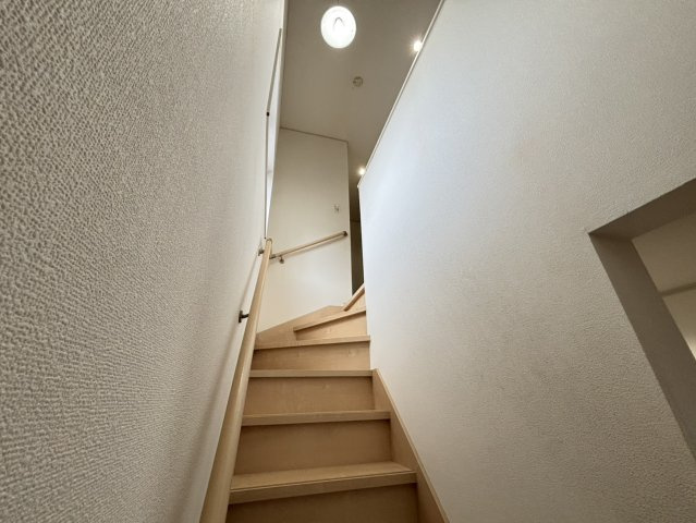 ナチュラルな木目の階段は、手すり付きで安全に上り下りが可能です。途中に明かり取りの窓があり、日中は自然光が差し込みます。段差の高さも程よく年配の方やお子様にも優しい設計となっています。
