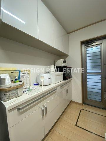 ゴミ出しなどに便利な勝手口、キッチンと統一感のあるカップボードがあります。　現地(2024年6月撮影)