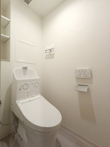 【トイレ】　スッキリとしたデザインの温水洗浄便座付きトイレ。小物やトイレットペーパーなどの収納も備わっています。