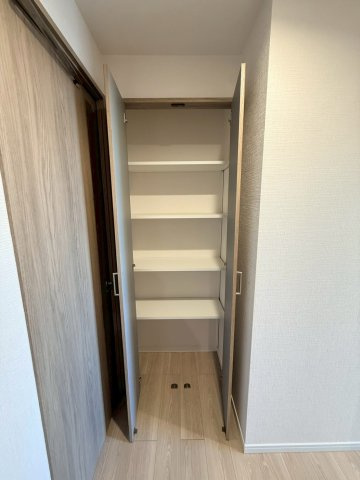 洗面所すぐ横の廊下収納、棚がありリネン等の収納にも便利です