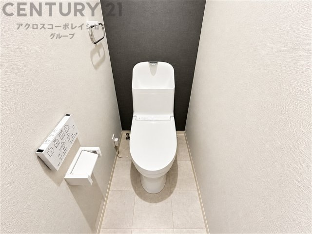 （分譲会社施工事例）　清潔感あふれるトイレ空間。落ち着きのあるアクセントクロスが上質な雰囲気を演出します。温水洗浄便座や手洗い付きで、毎日快適にお使いいただける設備が整っています。
