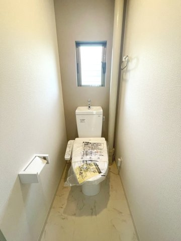 正面配置で使いやすく、ベージュの内装と窓でやわらかな印象の洗浄機能付きトイレです