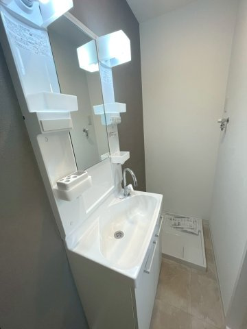 鏡まわりに小物を収めやすく、奥に防水パンを備えたまとまりのある洗面スペースです