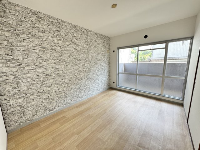 南東向きバルコニーに面した洋室6帖。大きな開口部から自然光が差し込み、明るく開放的な空間を演出します。アクセントクロスが室内のデザイン性を高め、おしゃれな雰囲気を演出。リビング続きの居室としても利用。