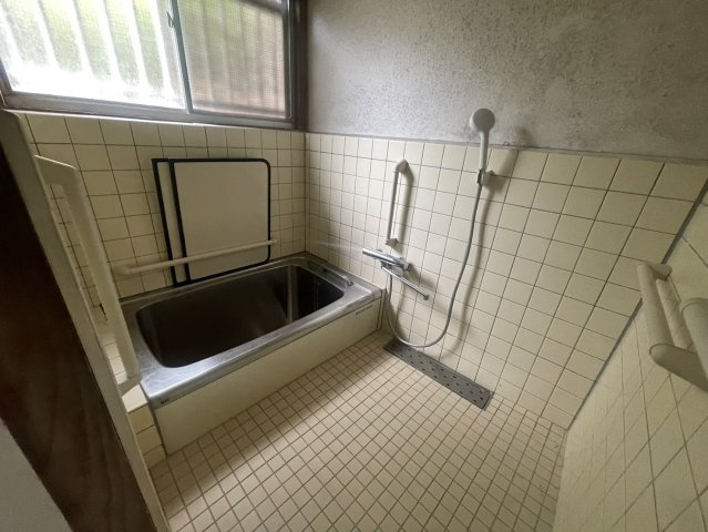 窓付きで自然換気がしやすい浴室です。浴槽に加えてシャワーや手すりも設置。タイル張りの昔ながらの浴室で、現況を活かして使用するほか、ユニットバスへの変更など水回りのリフォームもご検討いただけます。