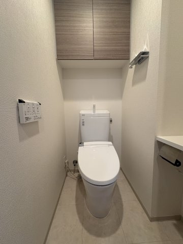 温水洗浄便座、上部吊戸棚付きのトイレです。