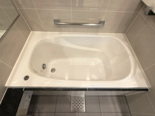 限られた空間を広く見せるワイドミラーを採用したバスルーム。　浴室換気乾燥暖房機付きで浴室内干しも可能！　深さのあるバスタブでゆったりと浸かることができます。