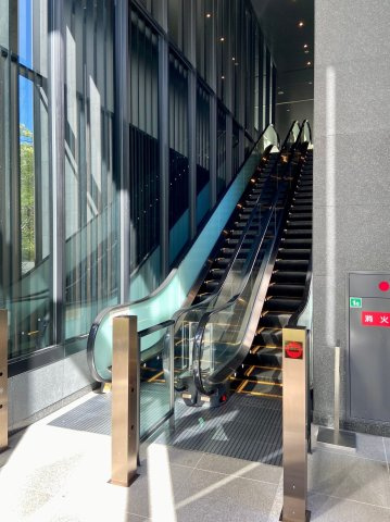 【エスカレーターホール】陽光溢れる三層吹き抜けの風除室です！エントランスホールはこの上にございます。