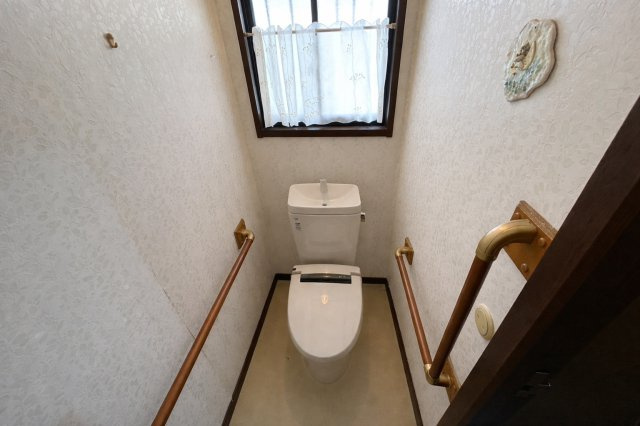 窓付きで明るさと換気が確保されたトイレ空間です。手すりが設置されており立ち座りに配慮した安心設計。シンプルで落ち着いた内装の為どなたでも使いやすい雰囲気です。