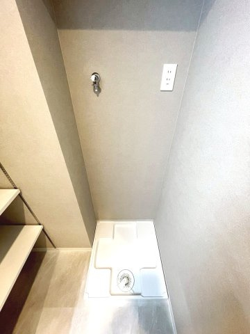 室内洗濯機置場、横には洗濯洗剤やリネンの整理等に便利な棚収納