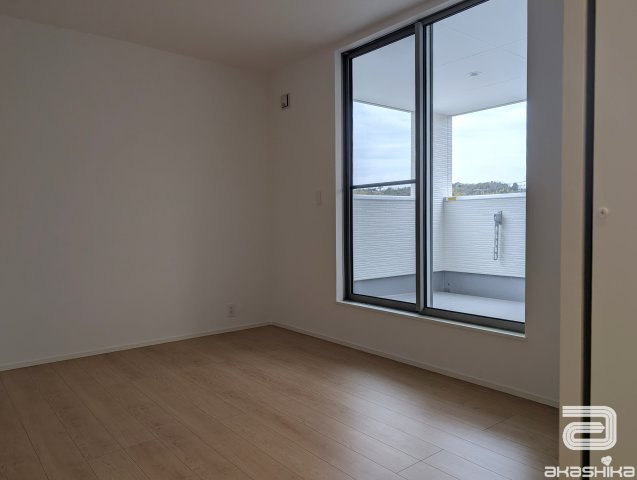 バルコニーに繋がる大きな窓から光が差し込む明るい部屋です。