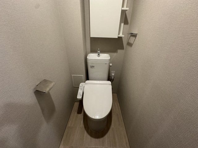 【トイレ】　手洗い器一体型のトイレは、温水洗浄便座付きです。吊戸棚があり、トイレットペーパーや掃除用具などのストックが可能です。