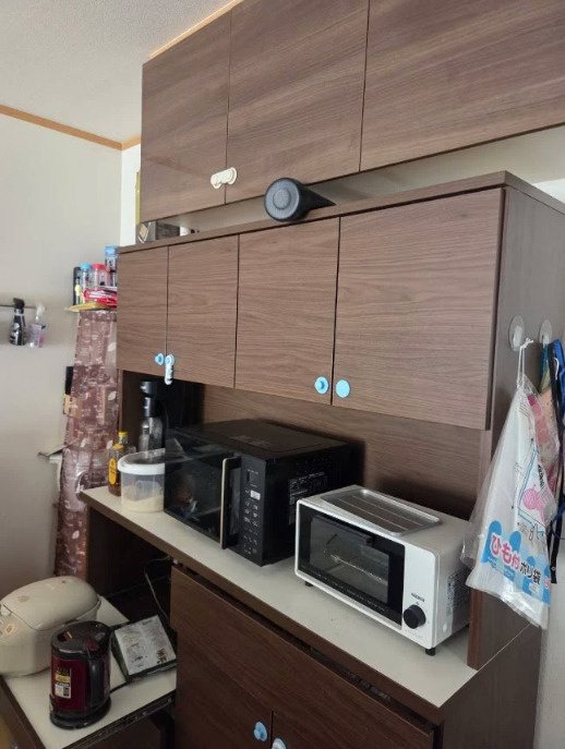 キッチン背面備え付けのカップボードがあります。食器をしまっておけるのでスッキリした印象になります。