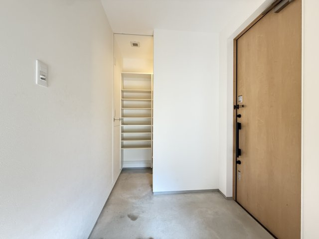 ゆとりある玄関ホールは動線が確保されており、スムーズな出入りが可能。土間部分も広く、ベビーカーやアウトドア用品の置き場としても活用できます。シンプルな内装で清潔感があり使い勝手の良い空間です。　