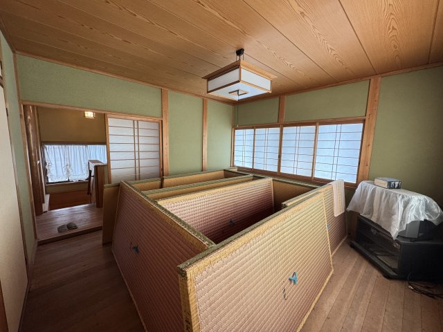 落ち着いた緑の壁面と木の天井が印象的な8帖和室。ゆとりある広さで主寝室や客間としても活用できます。押入れ収納も備わっており、寝具や季節物の整理にも便利。用途に応じて柔軟に使える落ち着きある空間です。