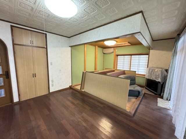 大きな窓から自然光が差し込み、明るく開放的な空間が広がります。奥には和室が続き間として配置されており、扉を開ければ一体利用も可能。来客時やお子様の遊び場としても活躍する、使い勝手の良い間取りです。