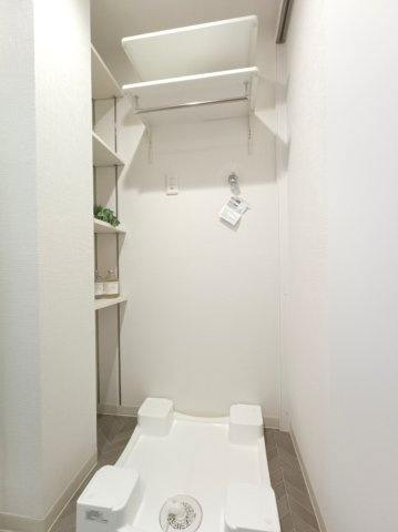 【室内洗濯機置き場】　棚板の高さを自由に動かせる可動棚を採用したニッチスペースに、ランドリーグッズやリネン類を収納しておけます。