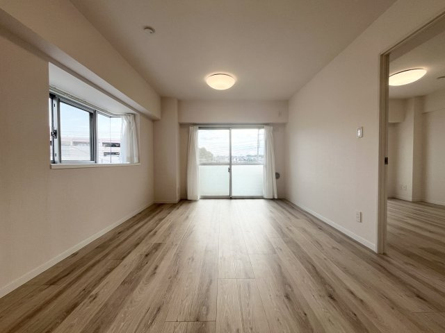 バルコニーに面した明るいLDK。大きな開口部から自然光が入り、家族でゆったり過ごせる空間です。