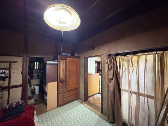 天井の梁と木目が美しい和室。壁一面に設けられた大型収納や和ダンスにより、衣類や生活用品をしっかり整理できます。畳の空間に十分な収納量が確保されており、寝室としても使いやすい一室。