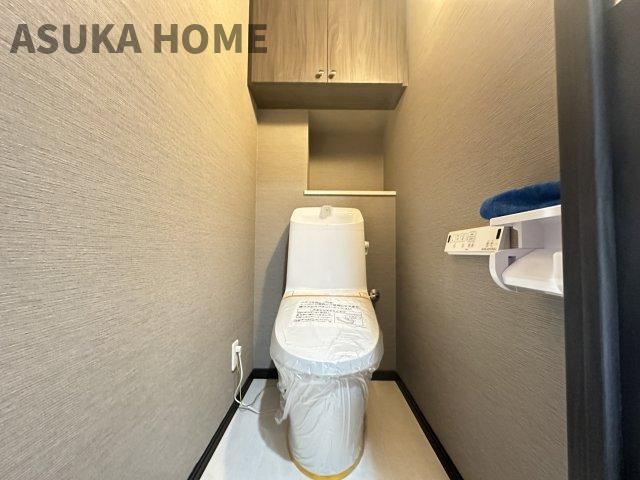 温水洗浄便座のトイレ設備です。トイレ上部にはあると便利な吊戸棚を設置。